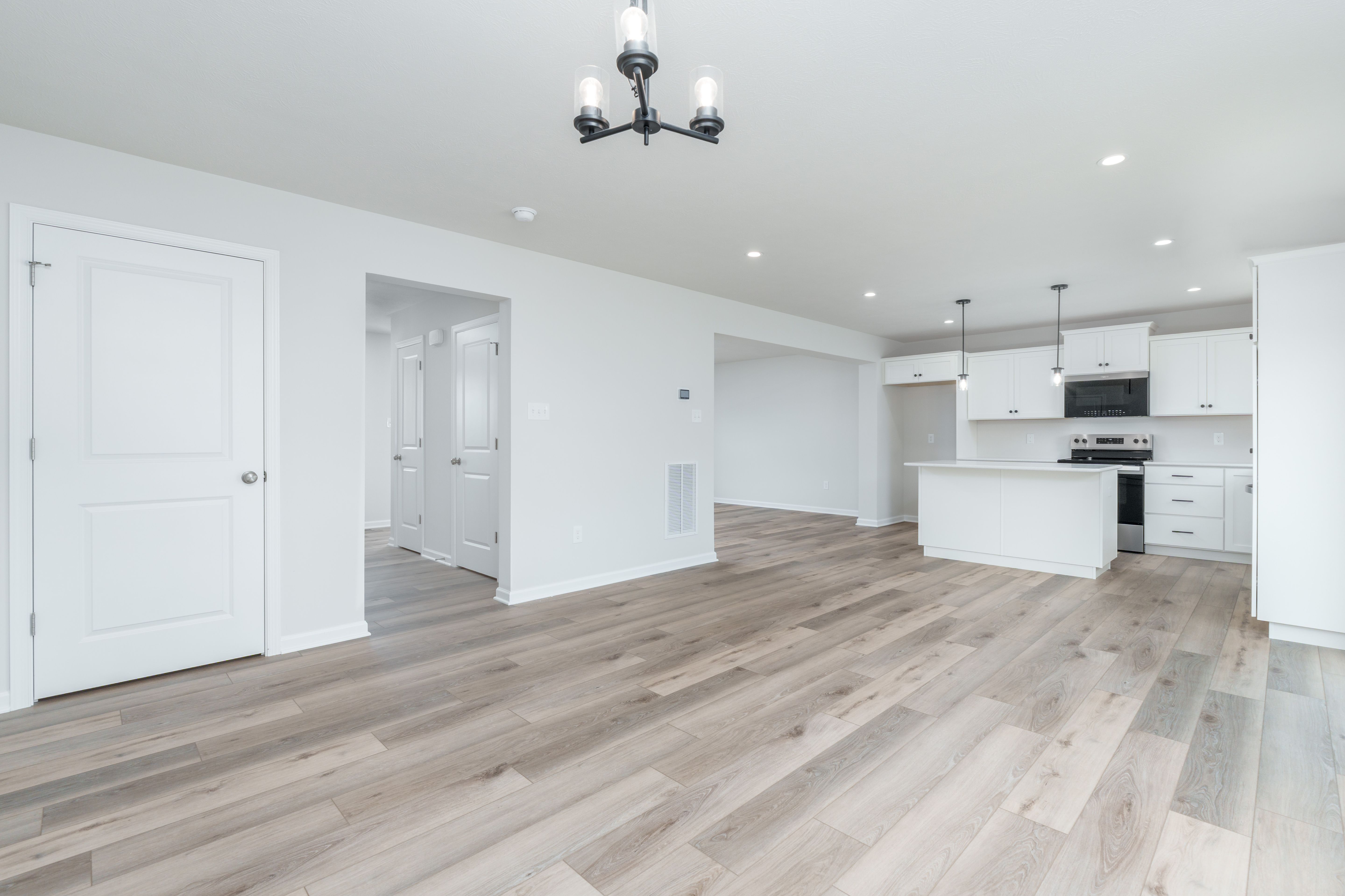 Breakfast area with chandelier lighting, sliding glass door, and large windows facing backyard.