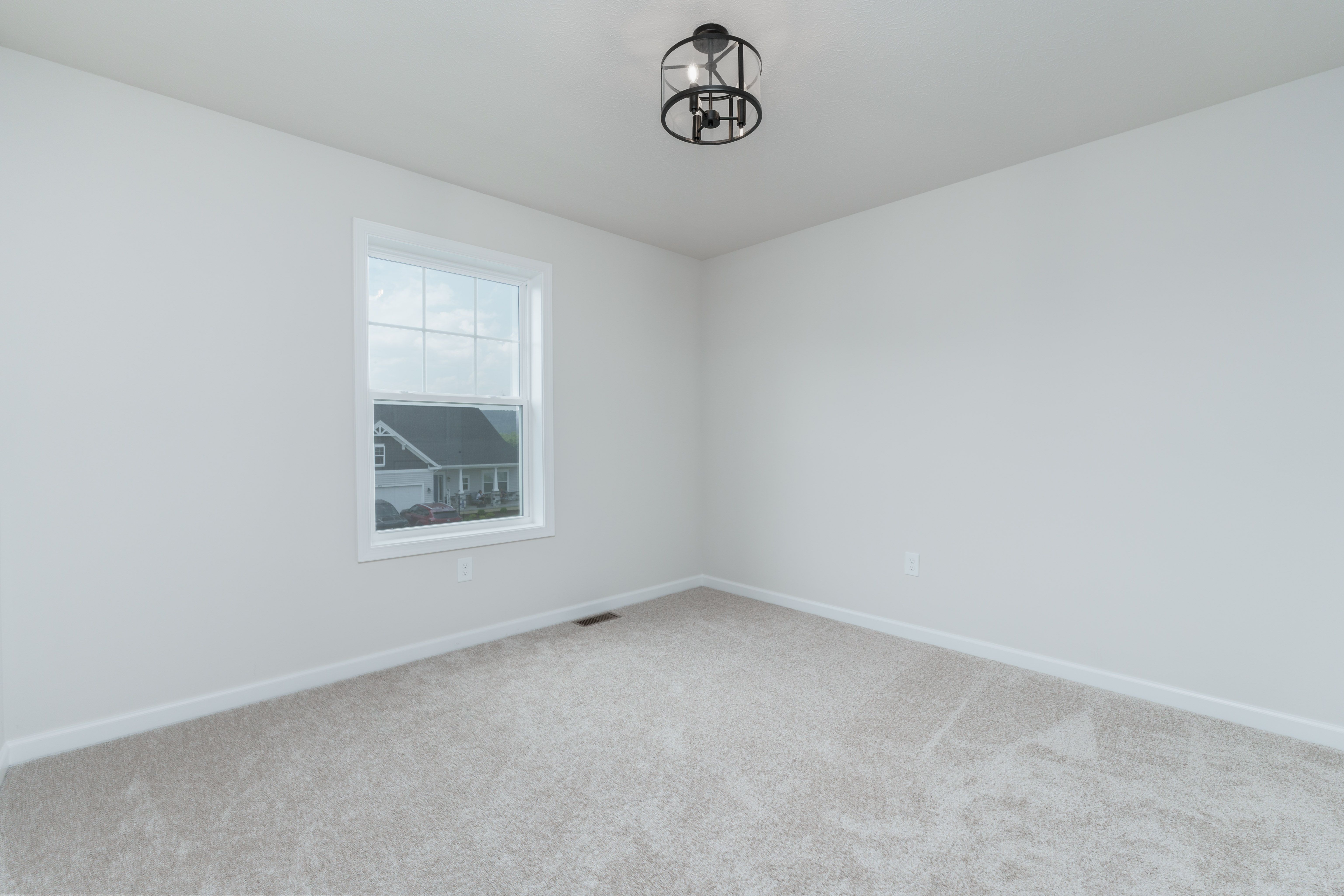Carpeted bedroom with a single window, soft gray walls, and a modern black cage ceiling light.