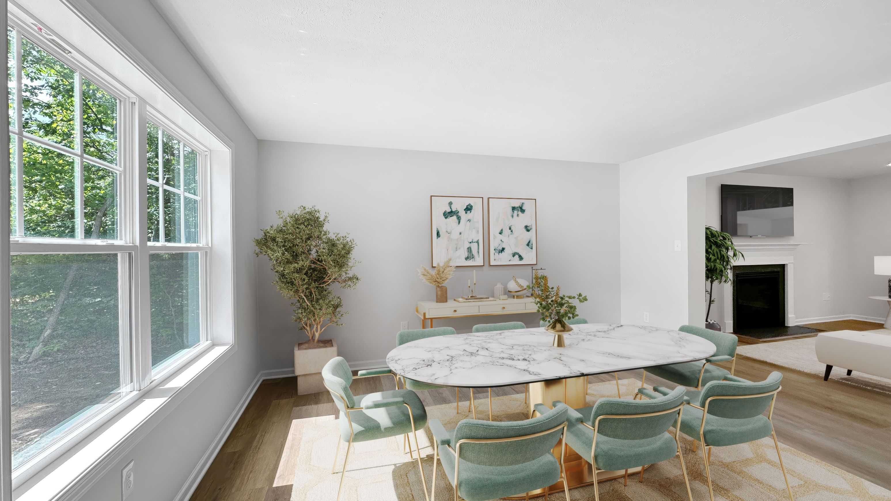 Dining area with large windows, marble table, teal chairs, contemporary decor, and views into adjacent family room.