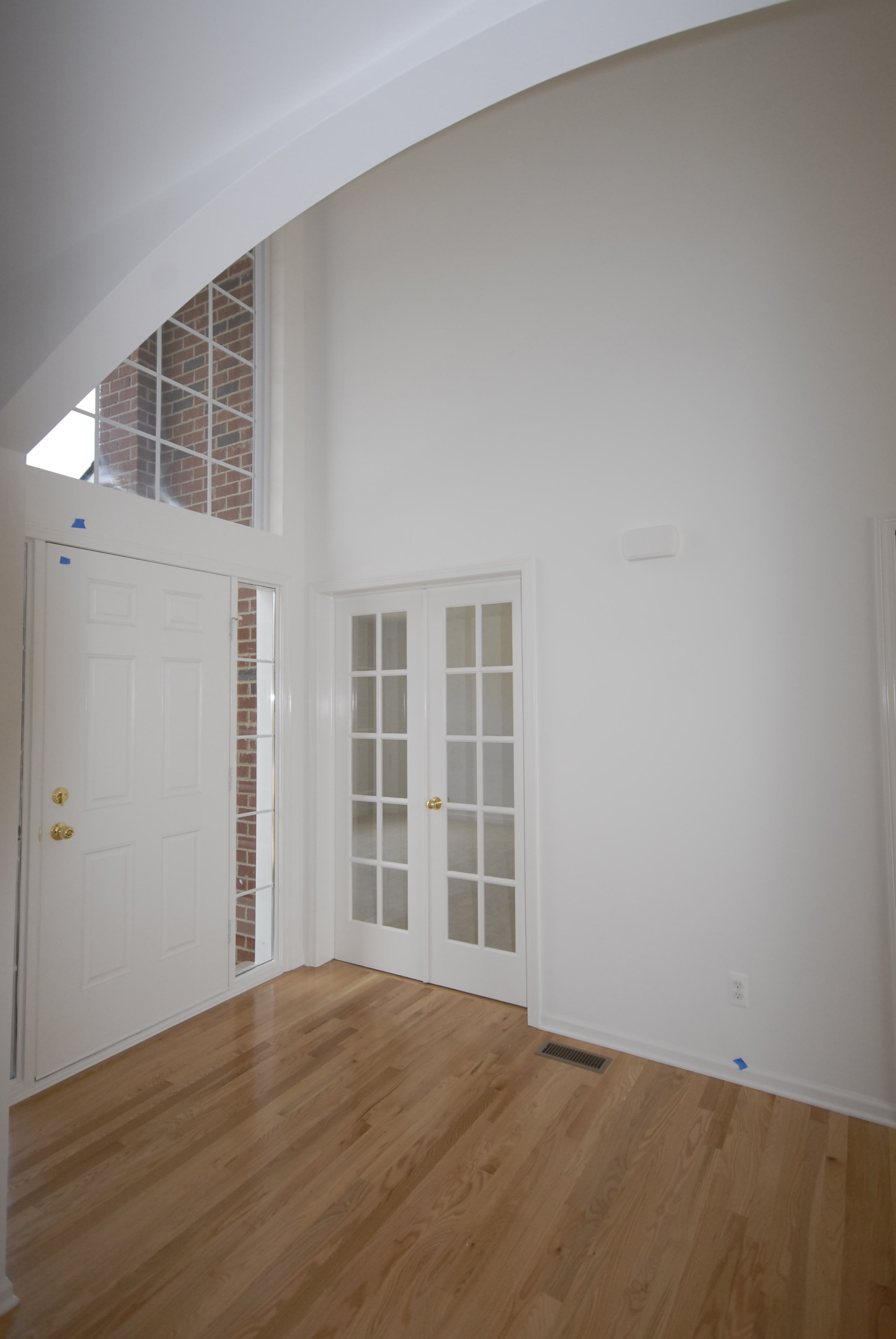 Grand two-story foyer with glass entry to private den.