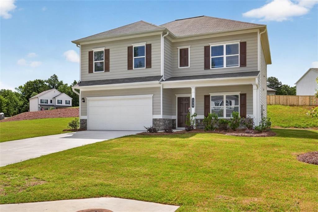 Two-story residence featuring light gray siding, dark brown shutters, and a covered porch entry