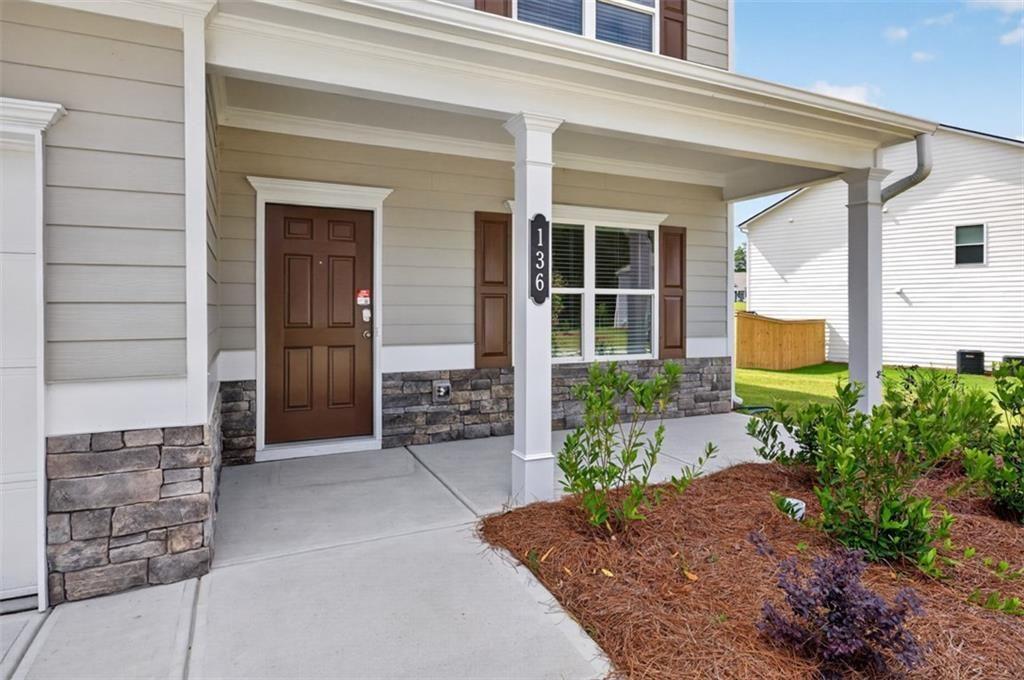 Covered front porch featuring stacked stone accents