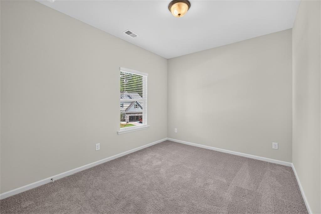 Neutral tone walls with white trim and grey carpeting