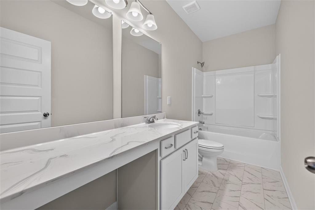 Bathroom featuring a vanity with a white countertop and integrated sink, white base cabinetry with