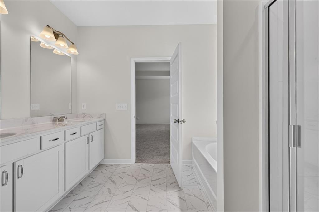Double vanity featuring undermount sinks and a stone-look countertop