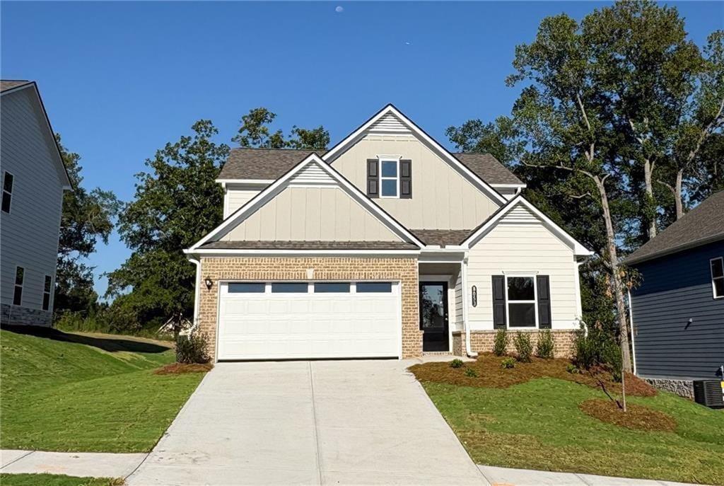 Two-story residence featuring a brick and siding exterior, a two-car garage, and a concrete driveway
