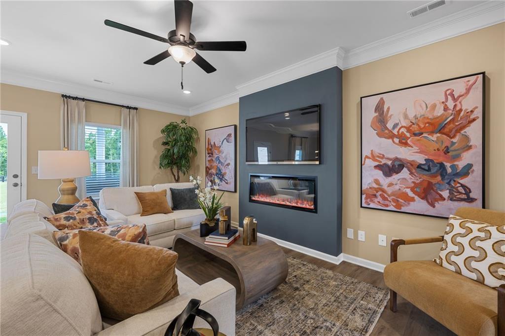 Recessed lighting, crown molding, ceiling fan, wood-finish flooring, and a linear electric fireplace