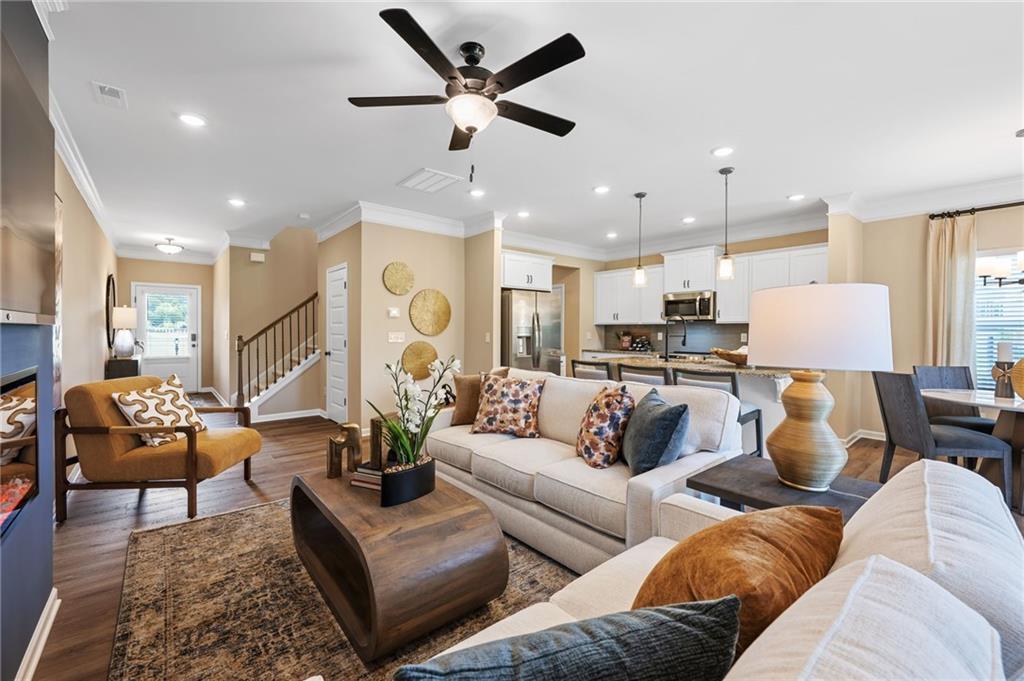 Open-concept living space featuring wood-finish flooring, recessed lighting, and a ceiling fan