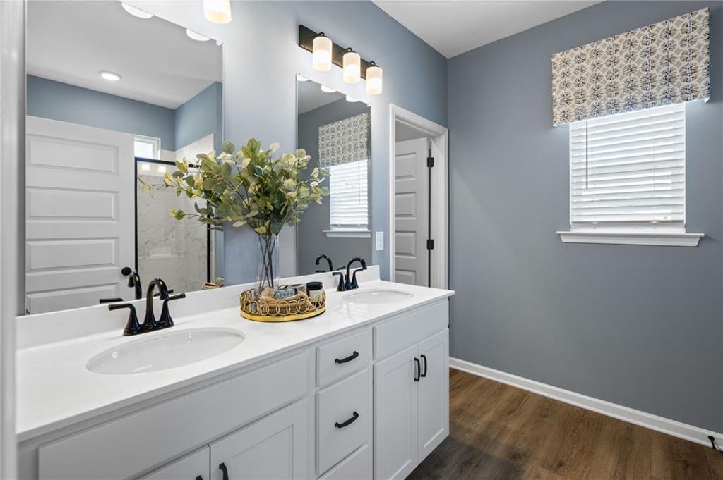 Dual vanity with white cabinetry, matte black fixtures, and integrated sinks