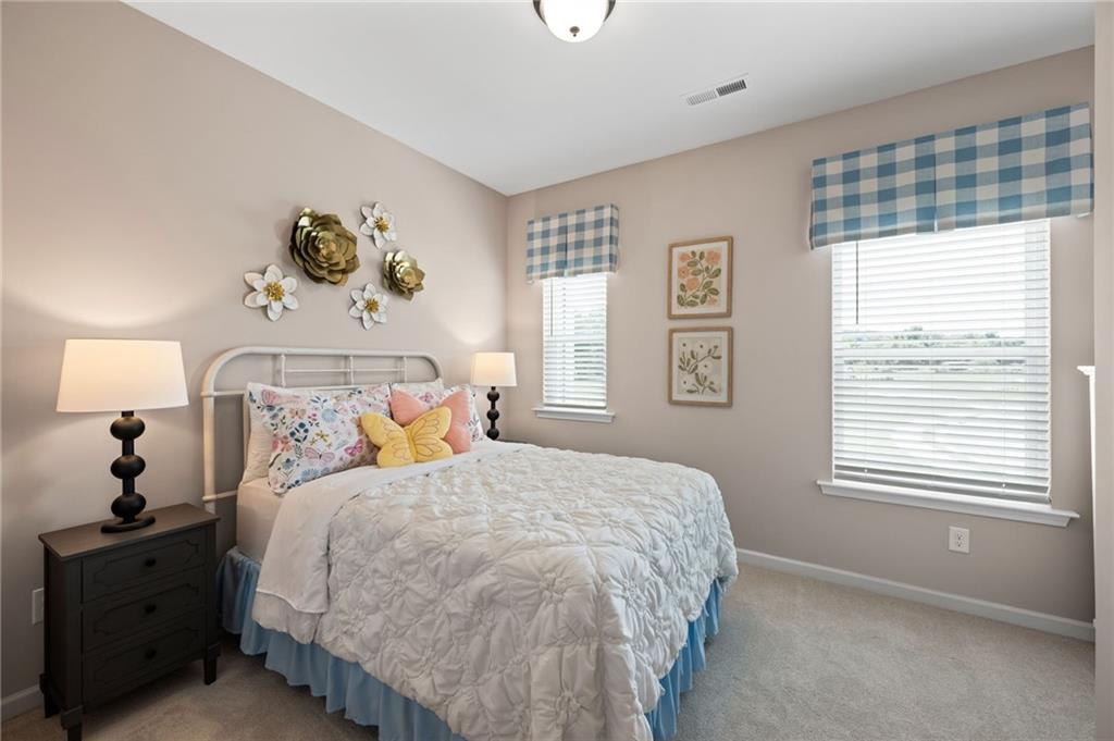 Neutral wall color, two windows with blinds, white trim, and carpeted flooring