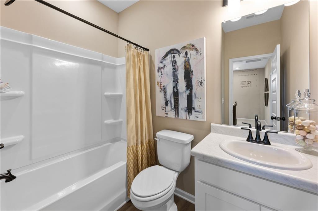 White vanity with a single basin sink, matte black faucet, and a large mirror