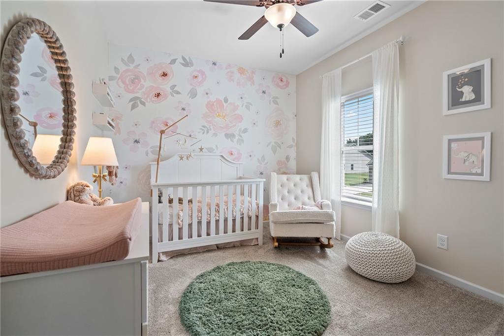 Neutral wall paint, ceiling fan, window with blinds, and light-colored carpeting