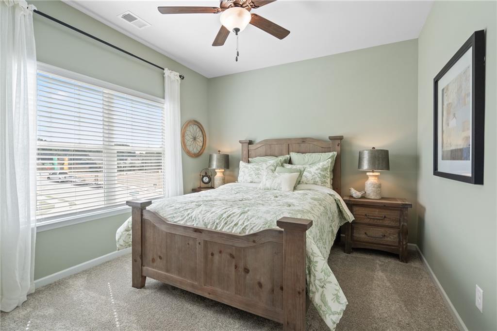 Carpeted room featuring a ceiling fan, window with blinds, and light-colored walls