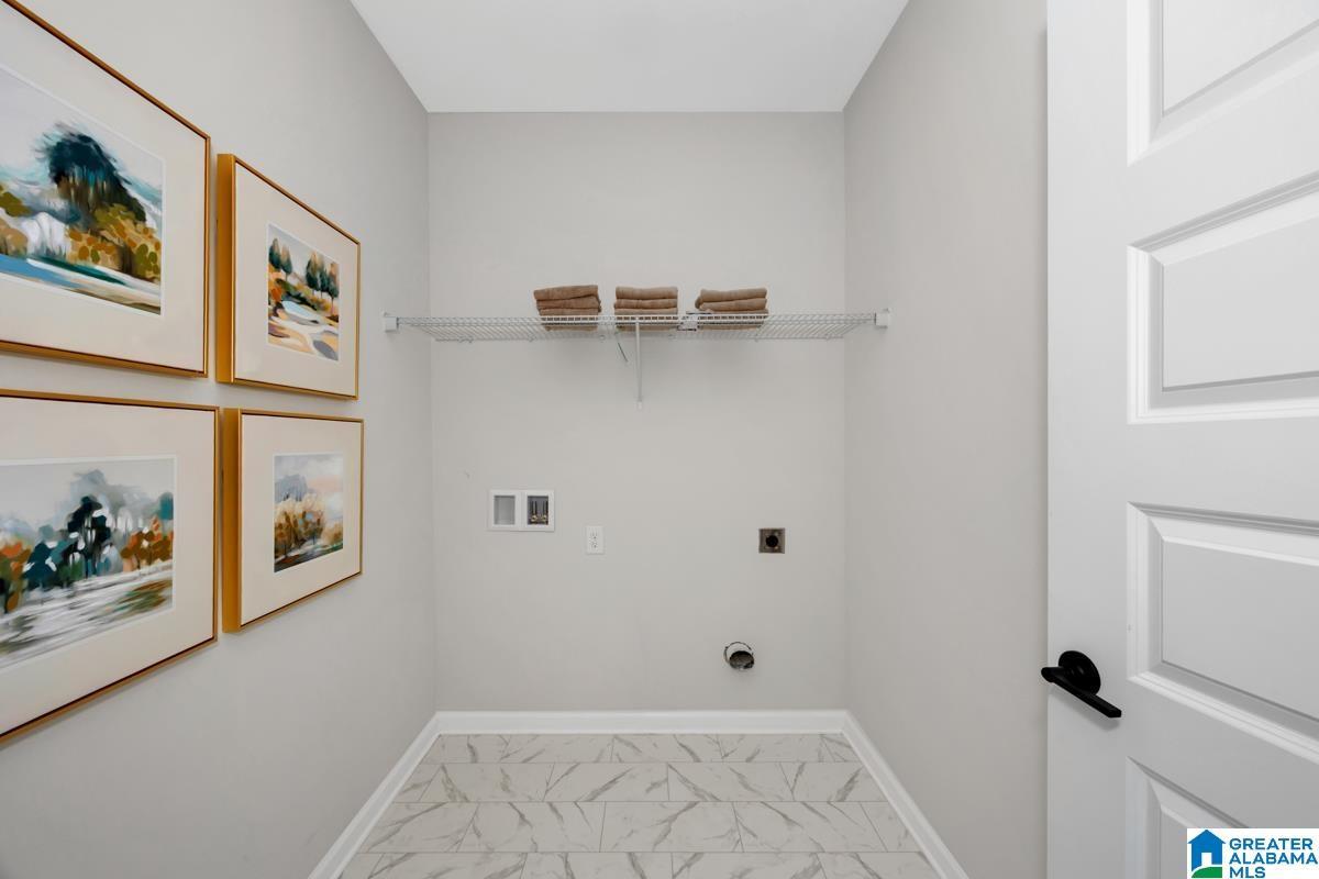 Tile flooring with a white finish, wire shelving, and a paneled door with matte black hardware