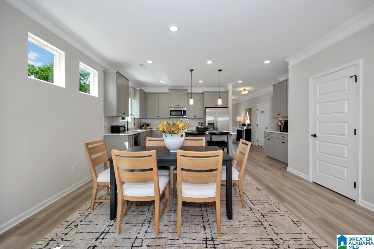 Recessed lighting illuminates the open-concept living space with wood-finish flooring