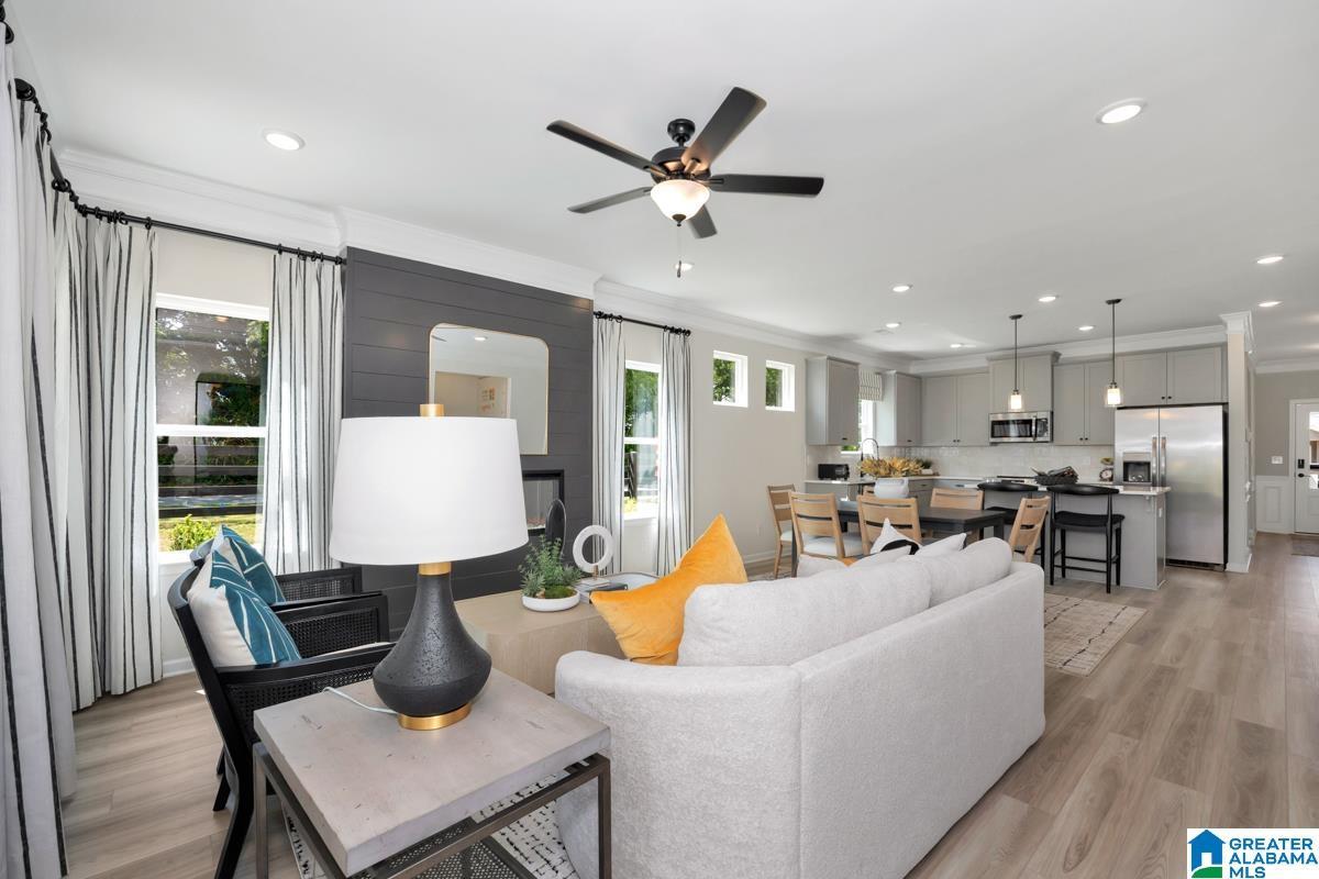 Open-concept living space with wood-finish flooring, a contemporary ceiling fan, and recessed lighting