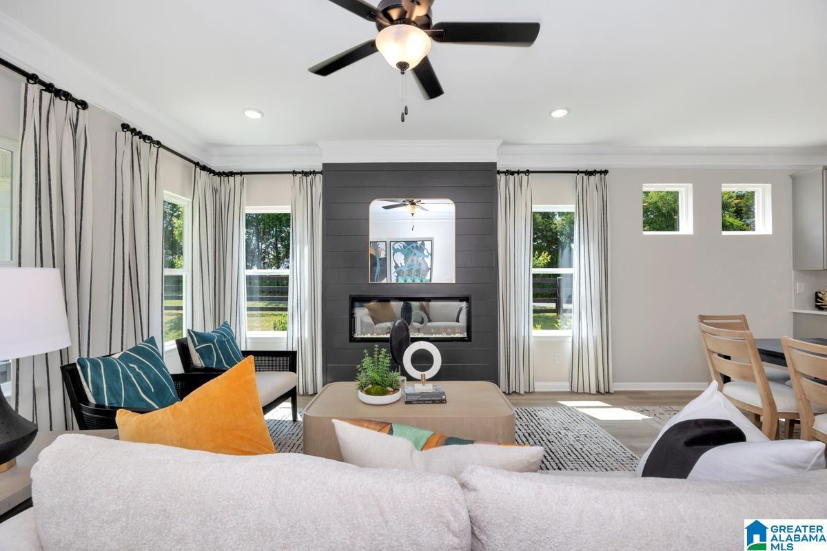Integrated living space featuring a dark shiplap accent wall with an electric fireplace, recessed lighting, and a ceiling fan