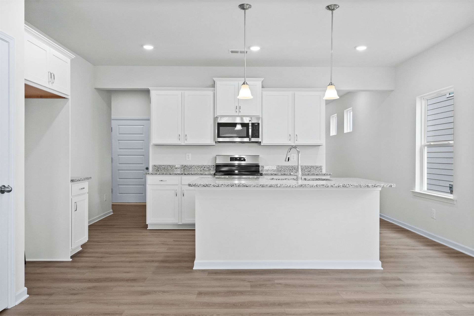 The Dove- Kitchen with Island. Home under construction, photo used for illustrative purposes only, colors and options will vary.
