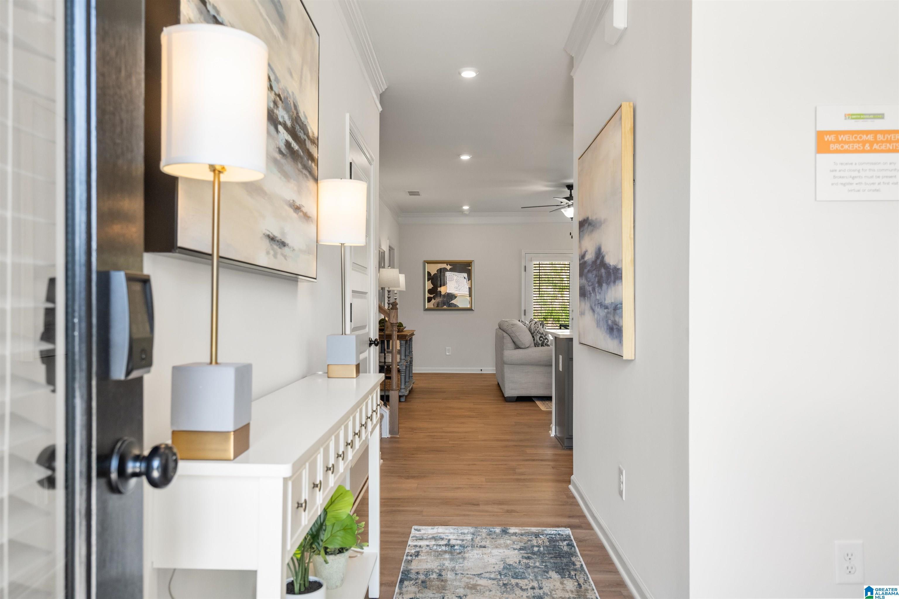Hardwood-finish flooring, crown molding, recessed lighting, ceiling fan, and white trim