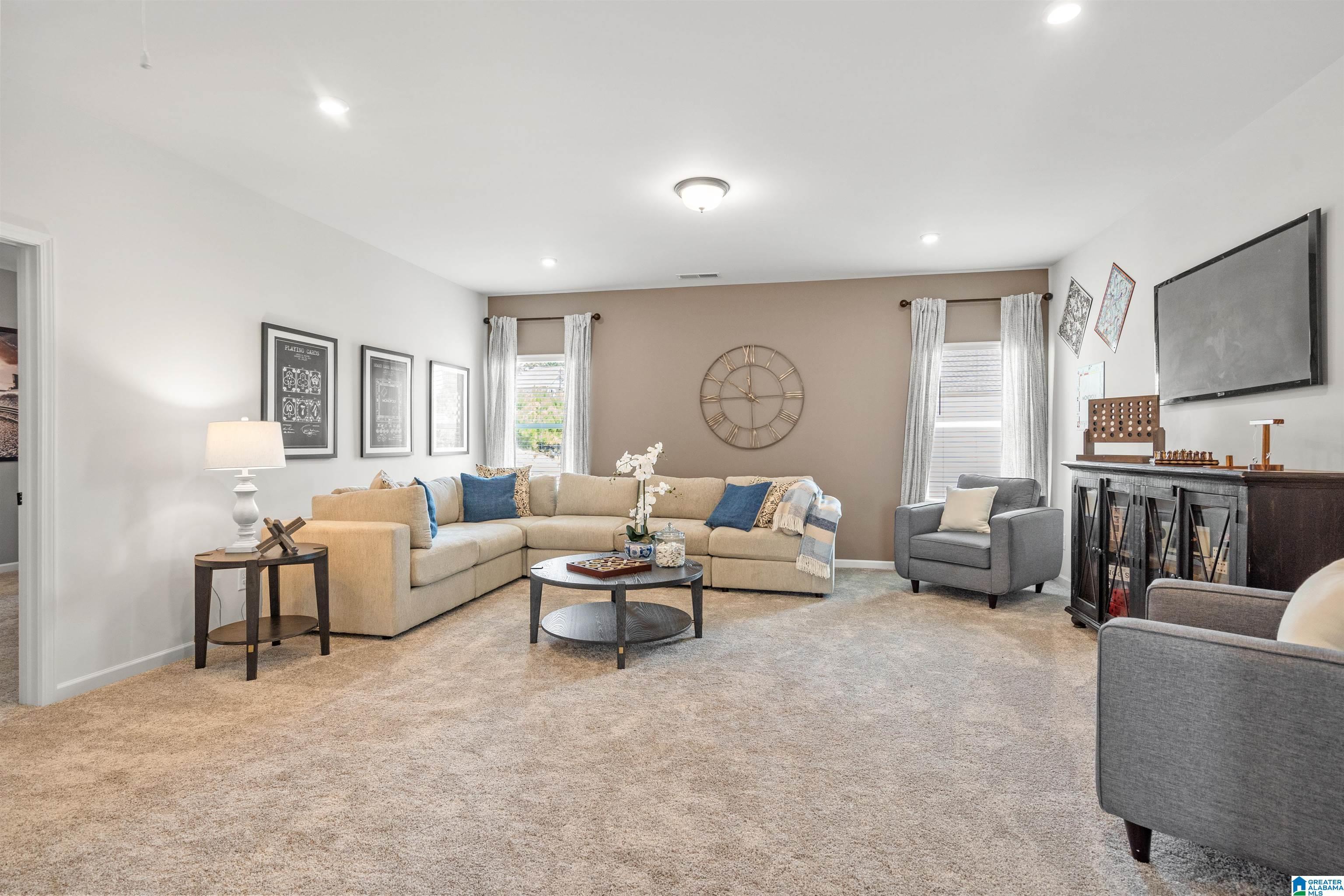 Plush carpeting, recessed lighting, and a wall-mounted television