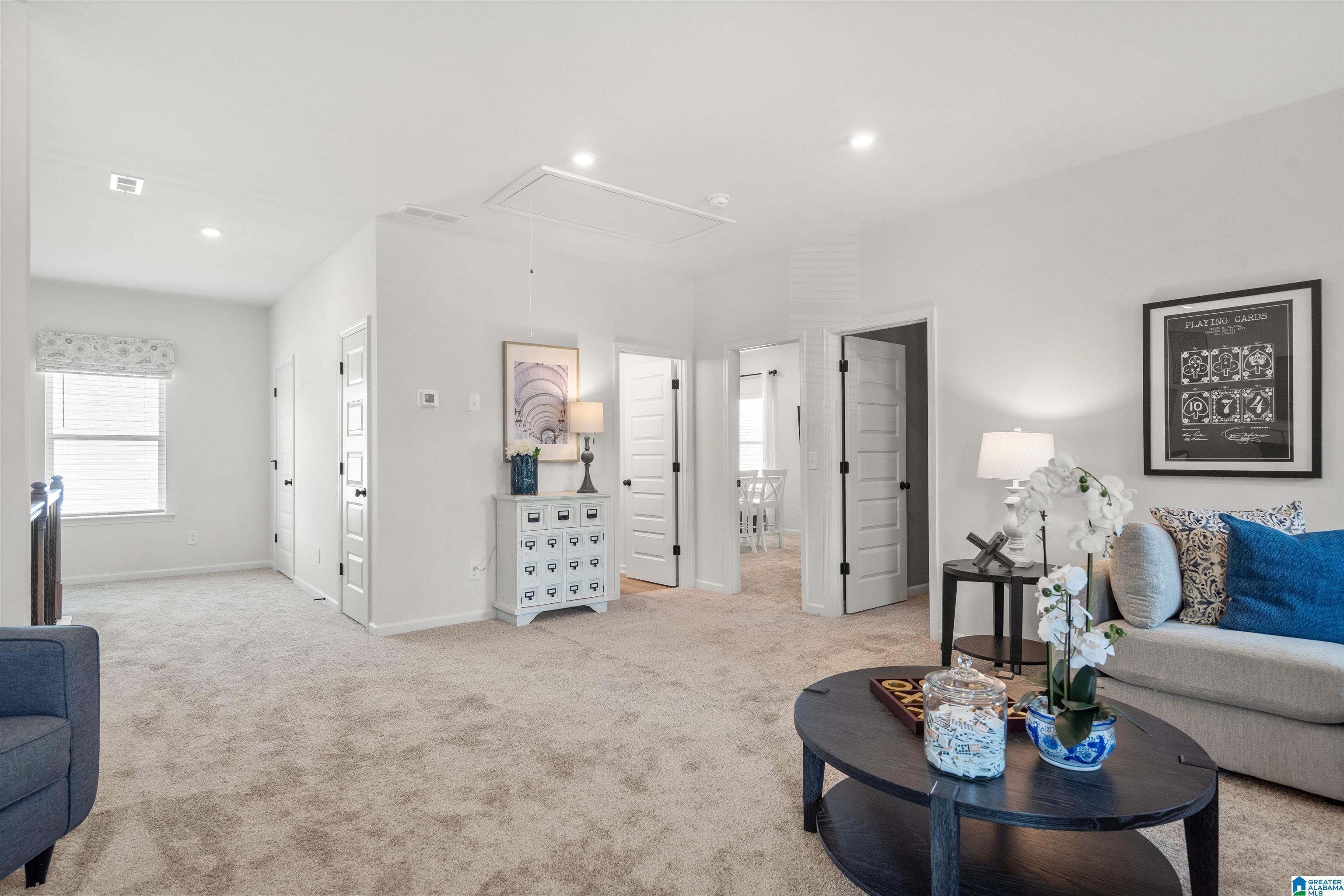 Carpeted flooring throughout, recessed lighting, multiple interior doors with dark hardware, and a window with blinds