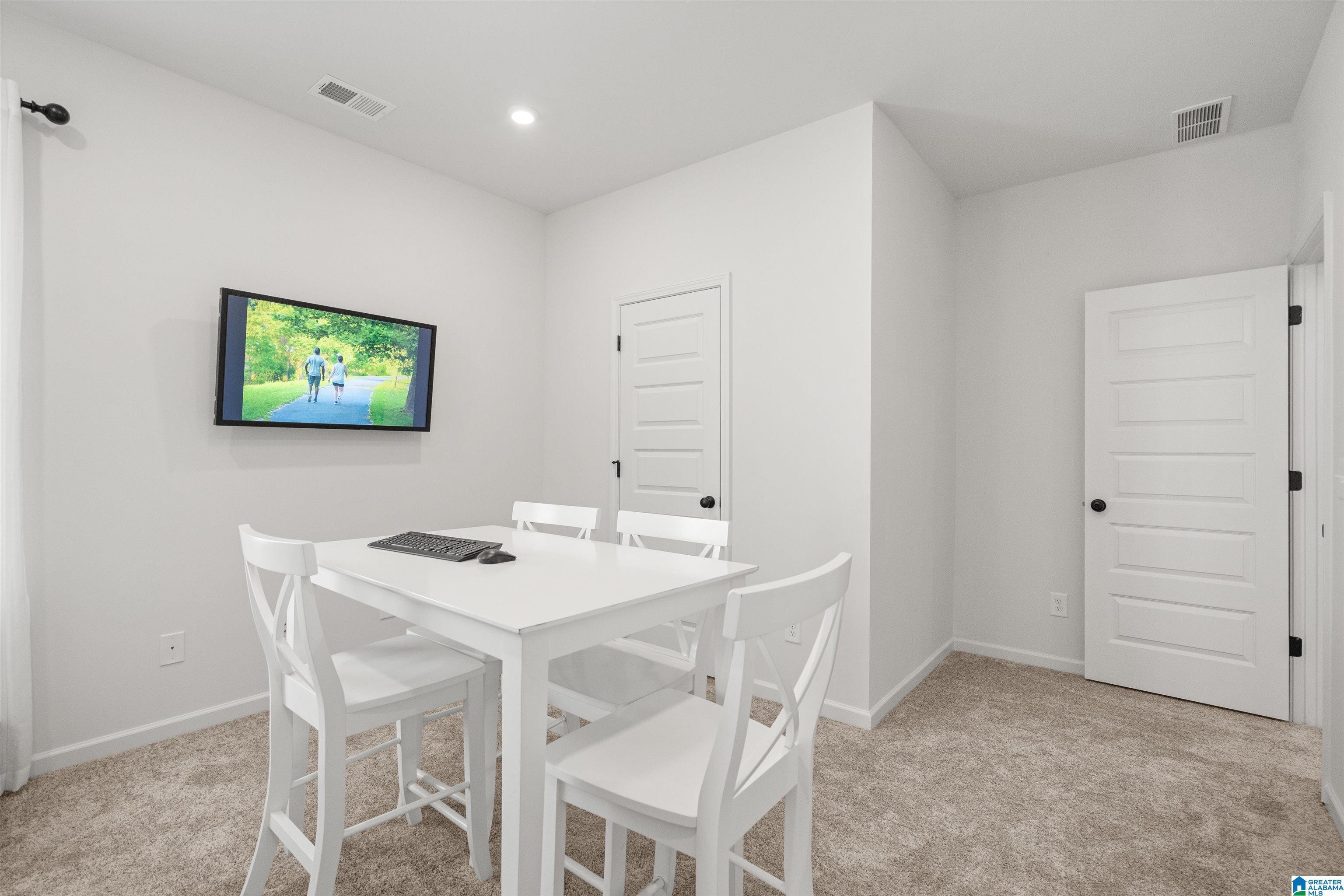 Carpeted room with recessed lighting and contemporary paneled doors