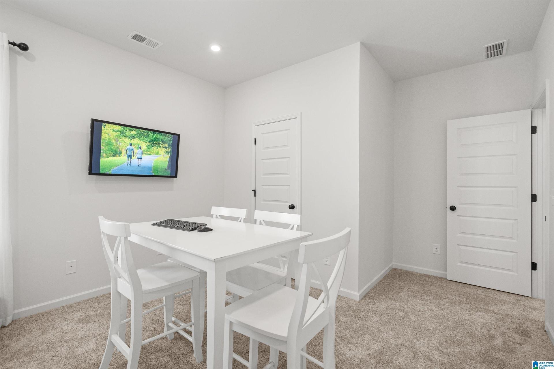 Carpeted room with recessed lighting and contemporary paneled doors