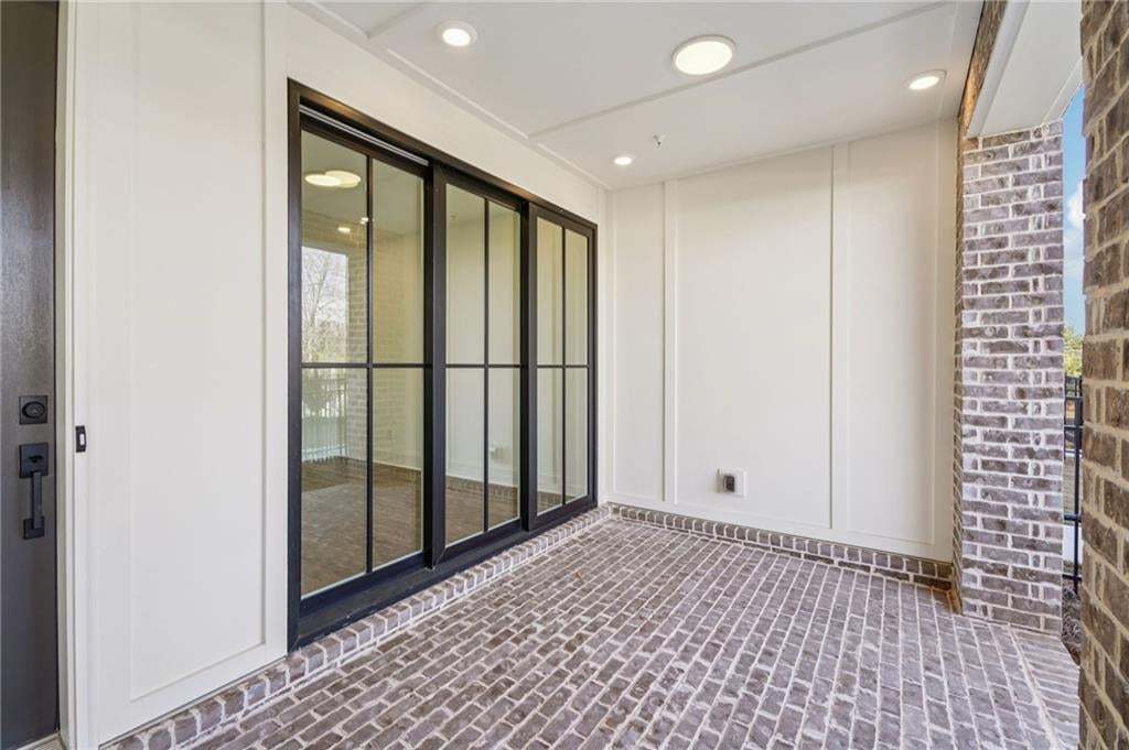 Covered patio with sliding glass doors leading to bonus room on terrace level.