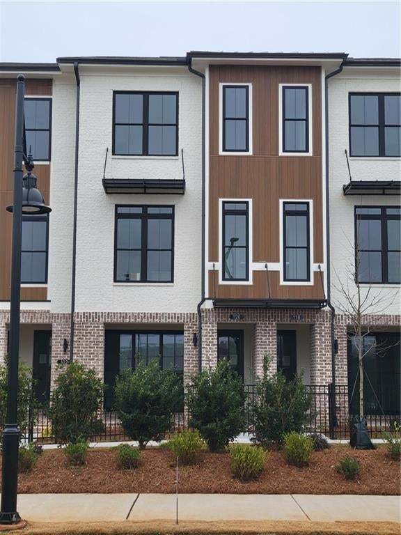 Exterior Photo of unit with Brick and Nichiha siding. Covered Patio with fenced in front yard.