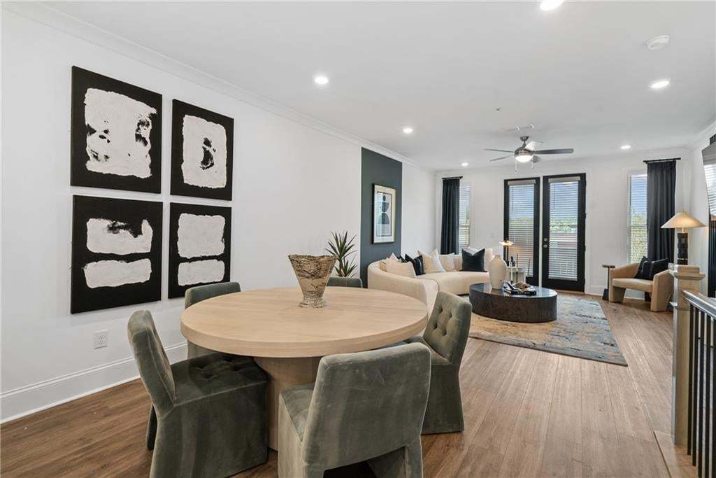 Dining space featuring crown molding, wood-type flooring, and recessed lighting open to kitchen and living room. *Photos are not the actual unit, but of the same floor plan and decorated model home.