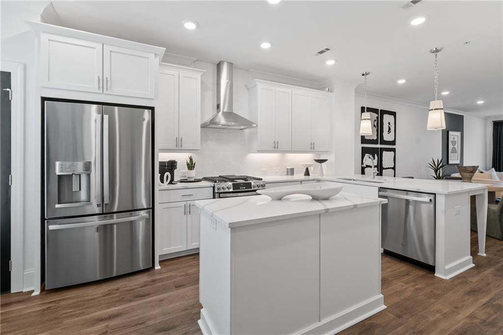 Kitchen features center island with quartz countertops and breakfast bar with pendant lights. *Photos are not the actual unit, but of the same floor plan and decorated model home.