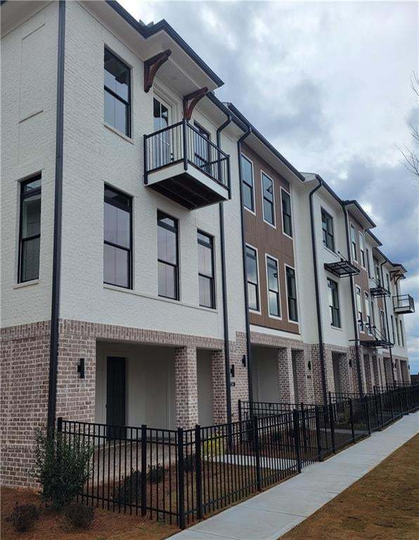 New Construction townhome with private front patios and stylish curb appeal. View of building. Lot 65 is interior unit.