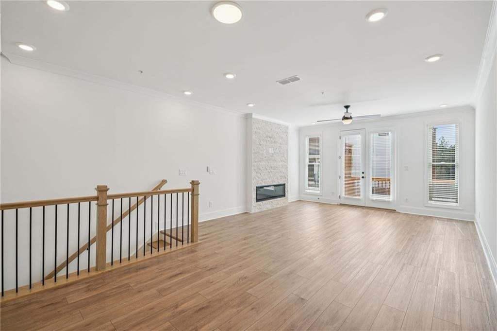 View from dining area to living room with electric fireplace and floor to ceiling stacked stone surround.
