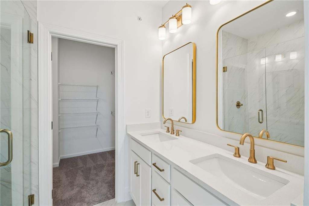 White cabinets with brushed gold fixtures and framed mirrors.