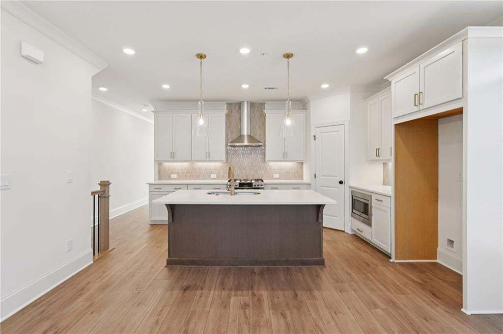 View from dining area to kitchen, with hallway leading to sunroom.