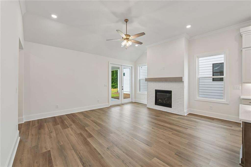 Spacious living area featuring high vaulted ceilings, recessed lighting, and wood-finish flooring