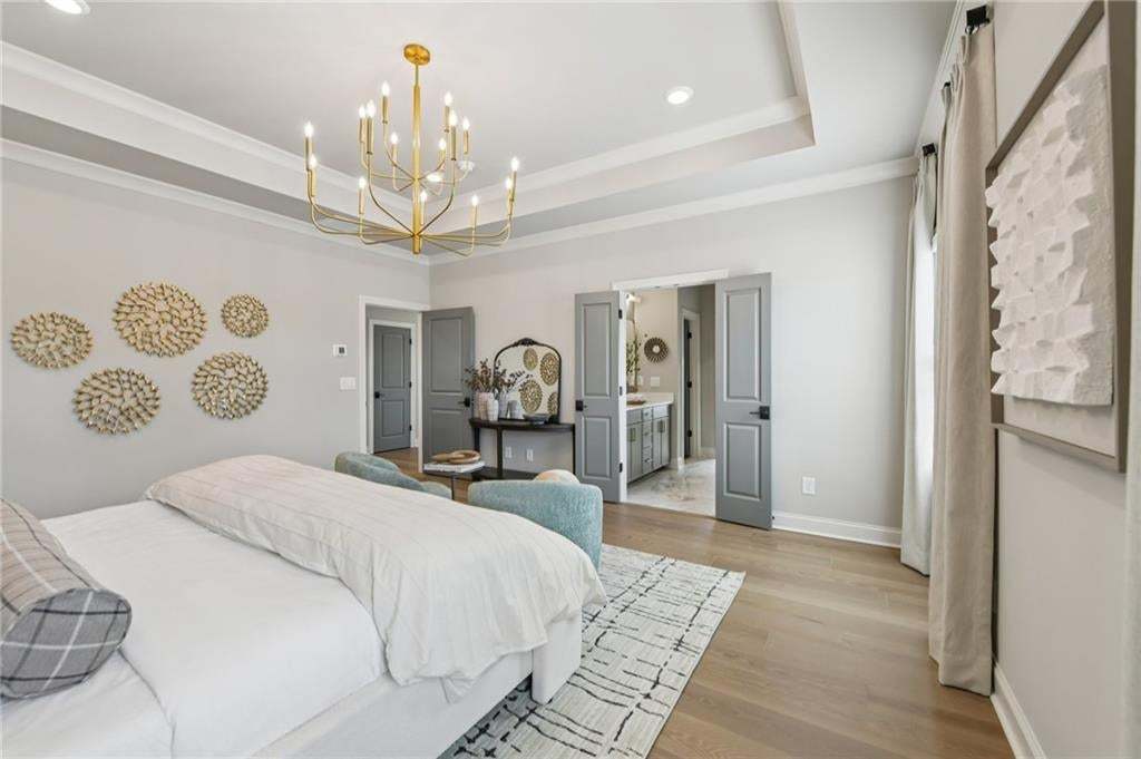 Primary bedroom with double doors leading to beautiful owner's bathroom. Photo not of actual home but for representation purposes only.