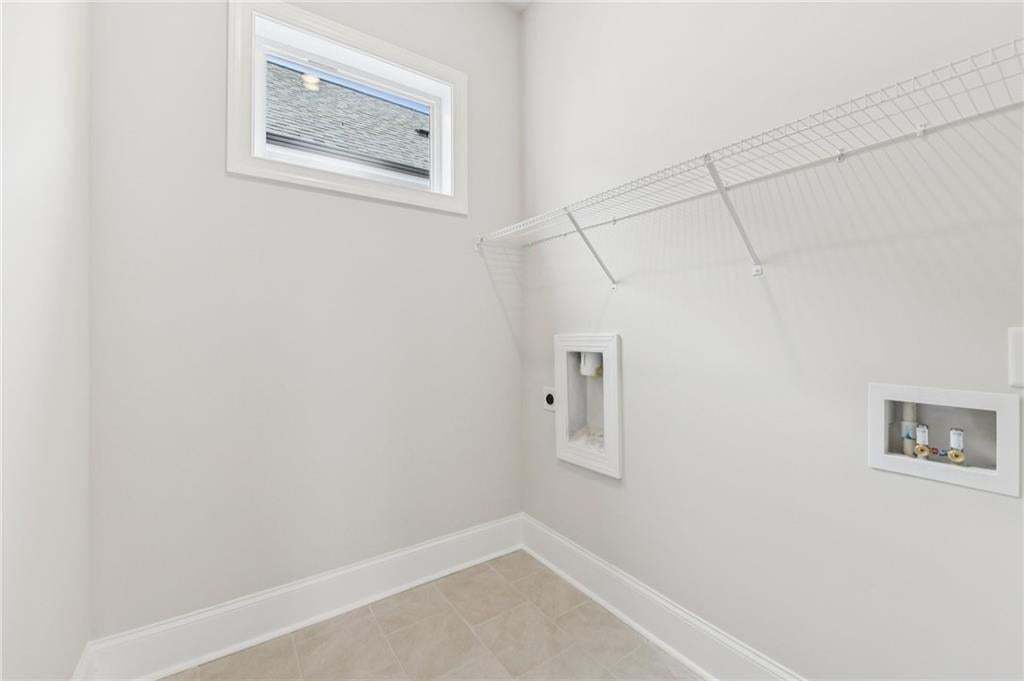 Laundry room with hookup for a washing machine and baseboards