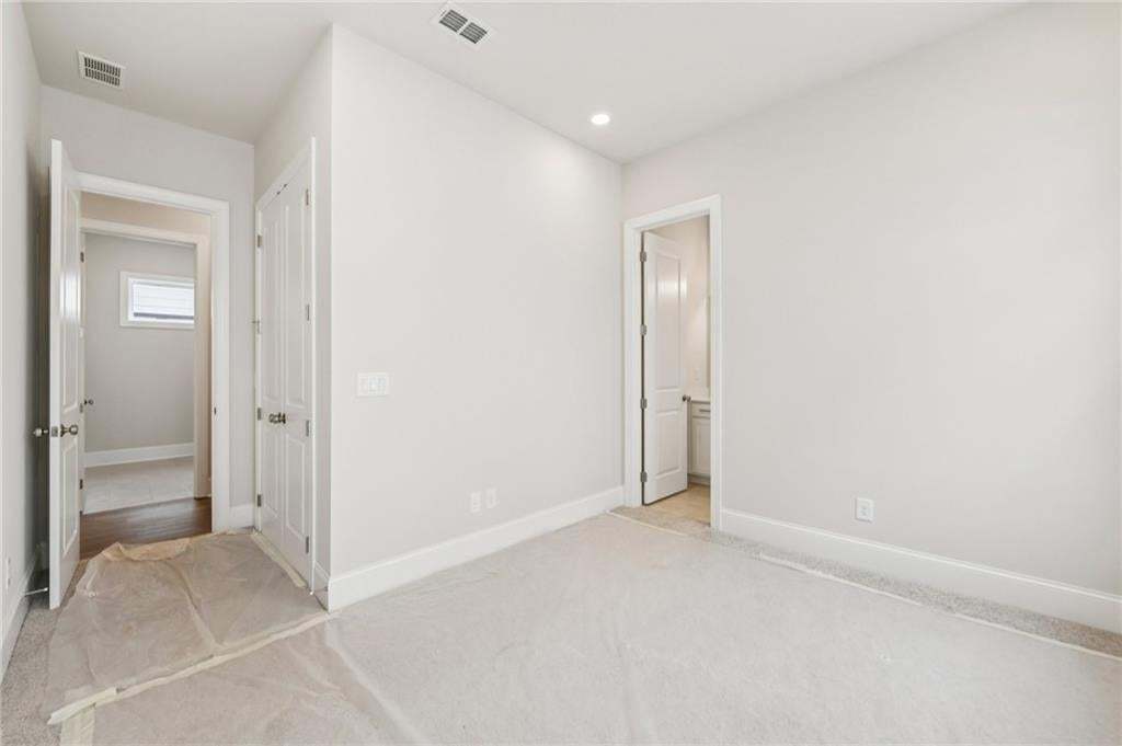 Unfurnished bedroom featuring light carpet and baseboards