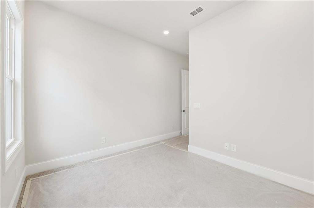 Unfurnished room with light colored carpet and recessed lighting