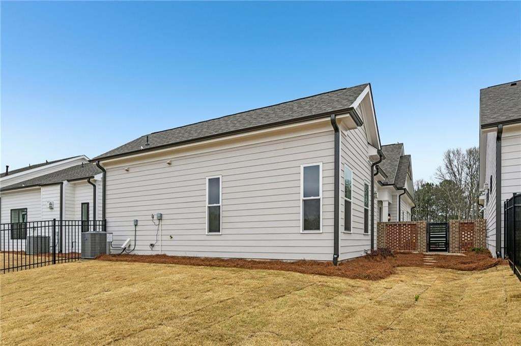 View of side of property featuring roof with shingles and a central AC unit