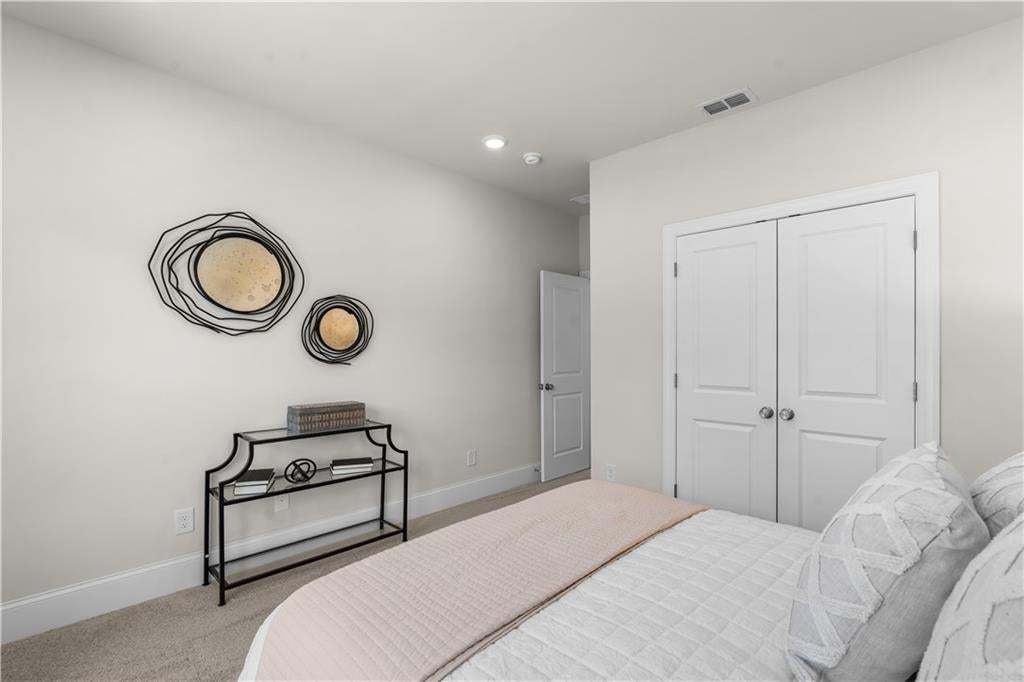 Neutral-toned room featuring a light carpeted floor and white baseboards