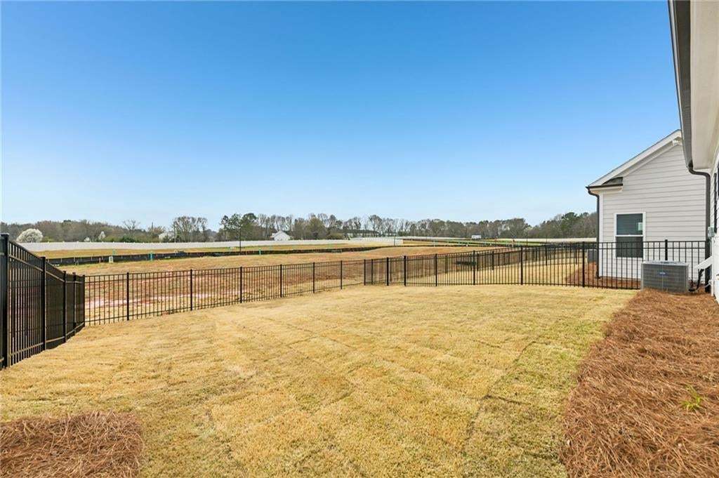Fenced backyard with a view of countryside
