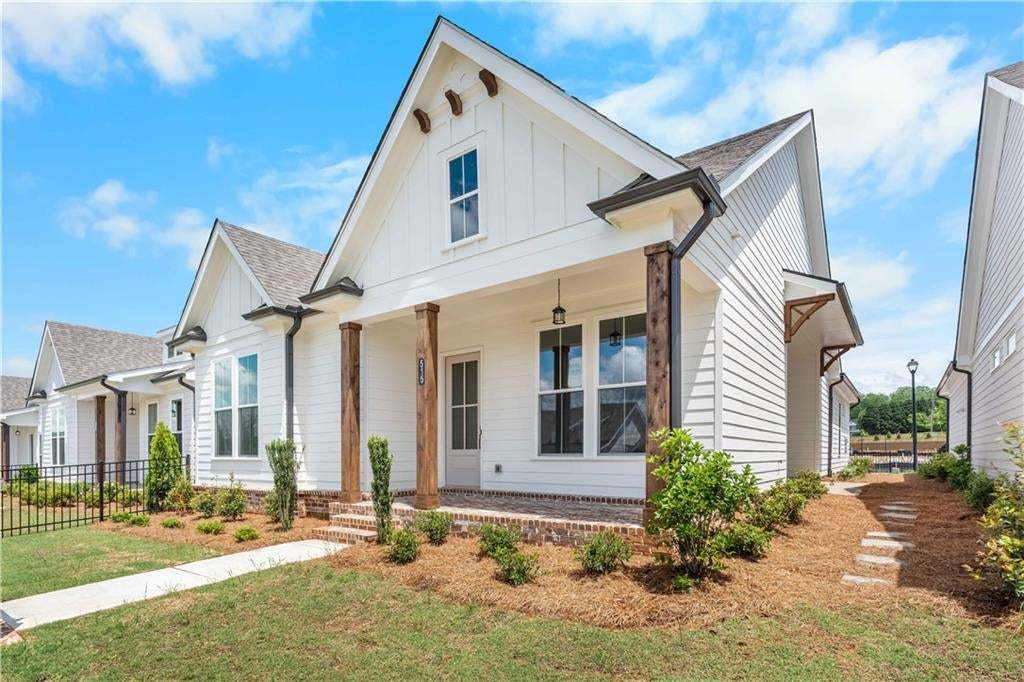 Modern inspired farmhouse with a porch, board and batten siding, and a shingled roof. Photo does not represent actual property but similar
