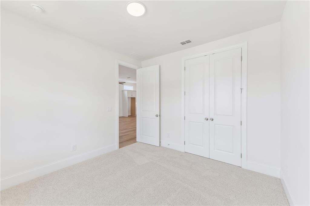 Neutral-toned wall-to-wall carpeting complements the white walls and trim