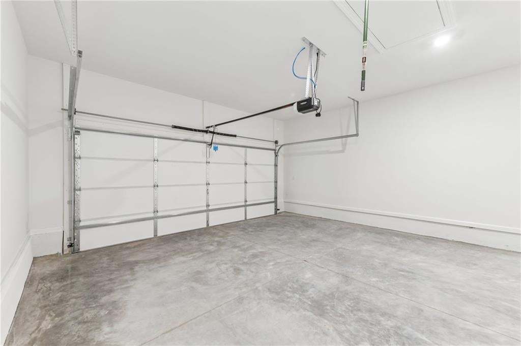 Attached garage featuring a concrete floor and white painted walls
