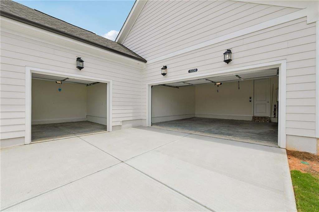 Attached two-car garage with overhead lighting and an interior access door