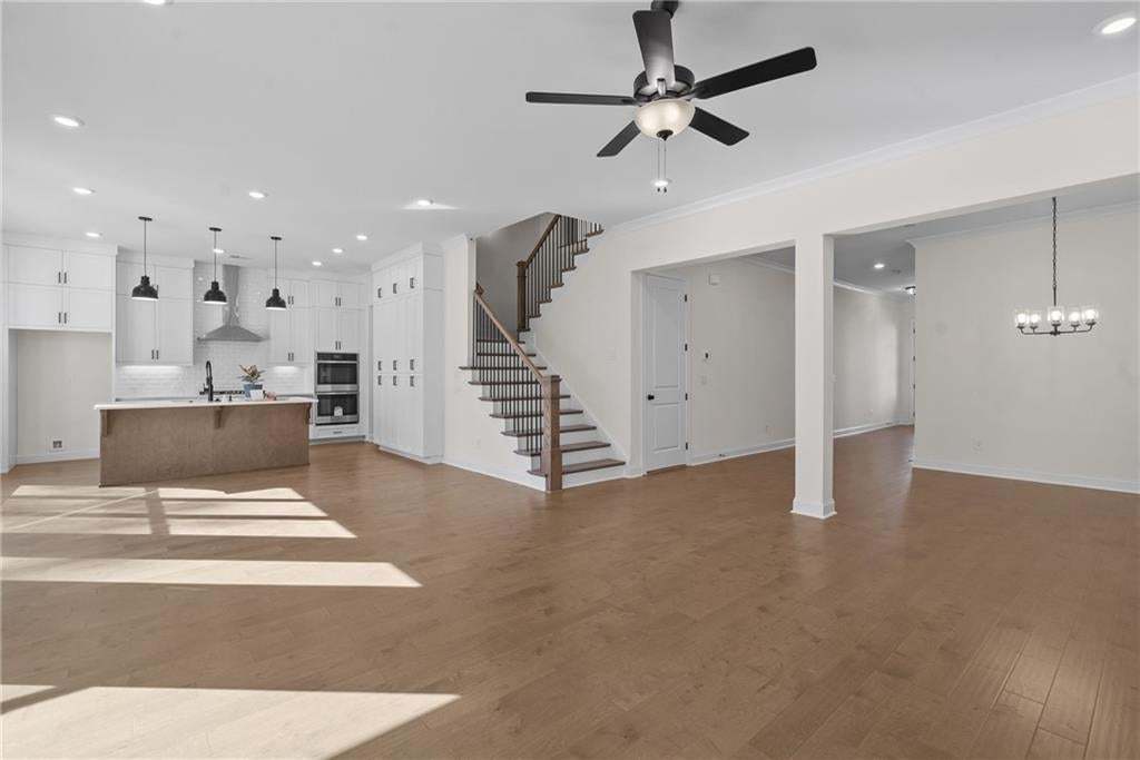 Room featuring multiple large windows, wood-finish flooring, white trim, recessed lighting, and a white ceiling