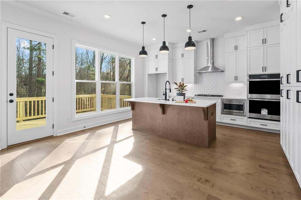 Contemporary kitchen featuring a large central island with a light-toned base and a white countertop