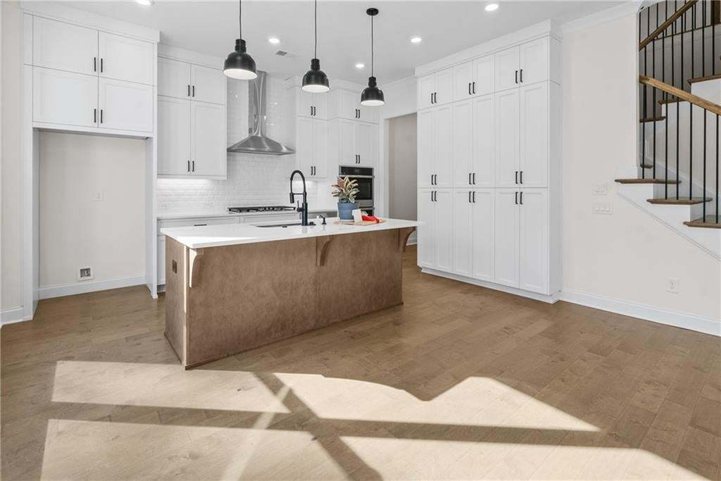 Spacious room featuring wood-finish flooring, recessed lighting, and white trim throughout